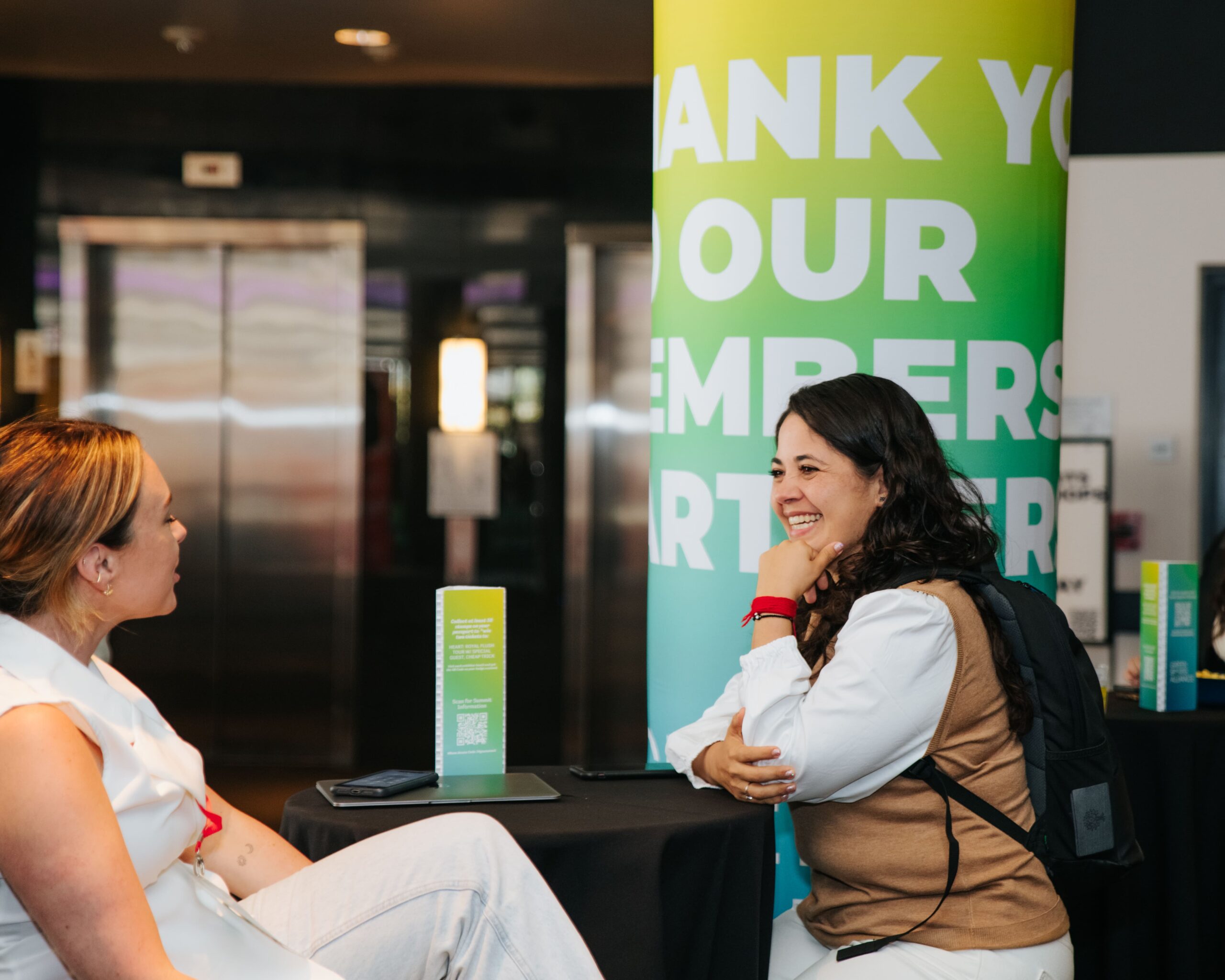 Attendees networking in front of Green Sports Alliance event branding during the sustainability conference .