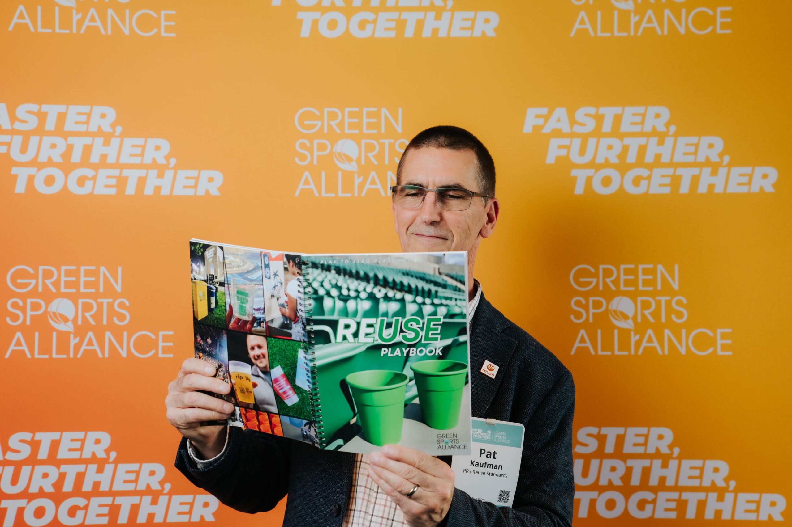 Conference attendee reading the Green Sports Alliance Reuse Playbook at the sustainability summit.