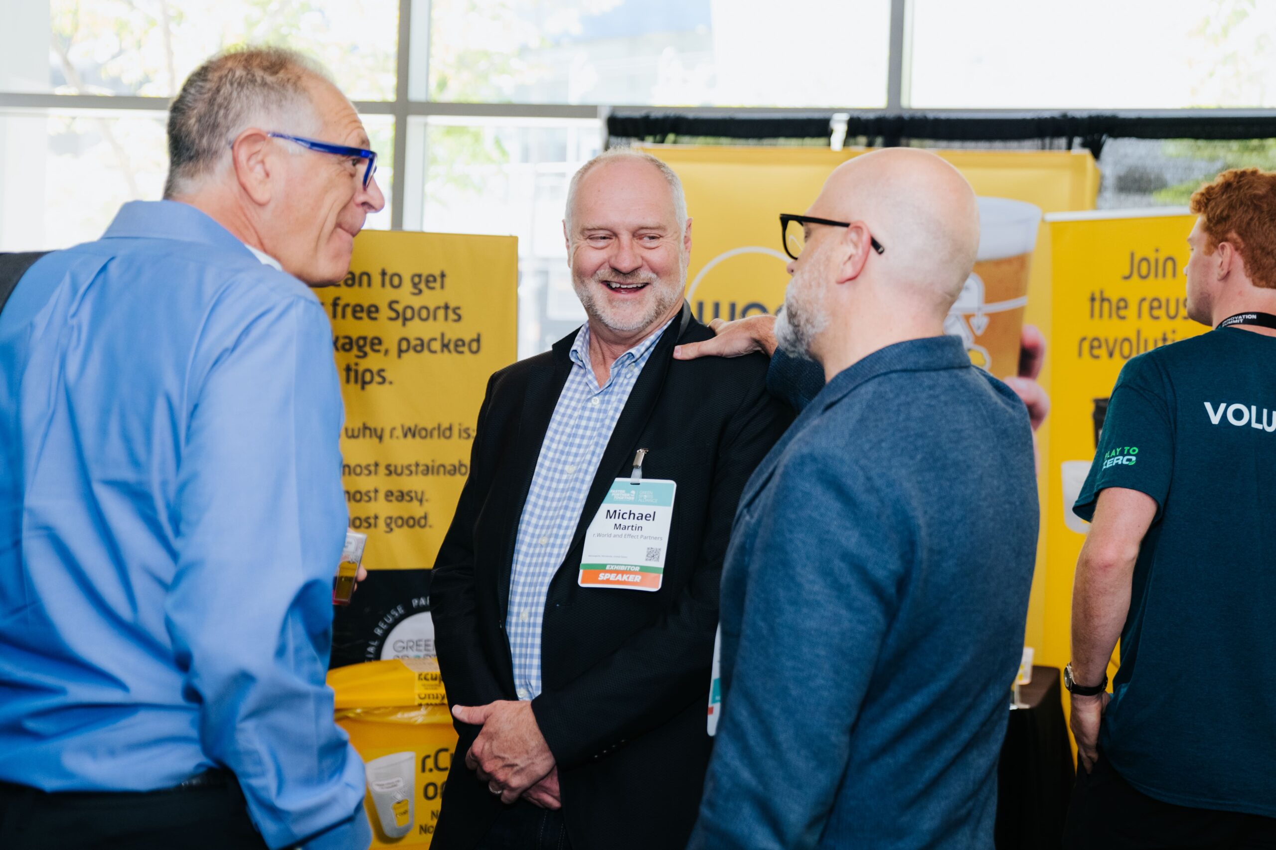 Conference attendees networking during the Green Sports Alliance Summit exhibition.