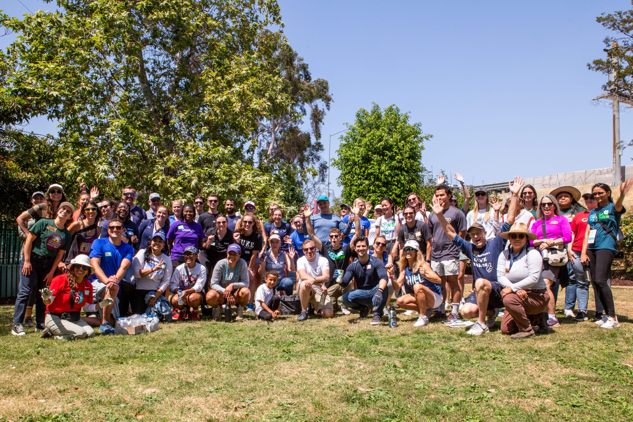 Volunteers and attendees gather for a Green Sports Alliance community sustainability event outdoors.