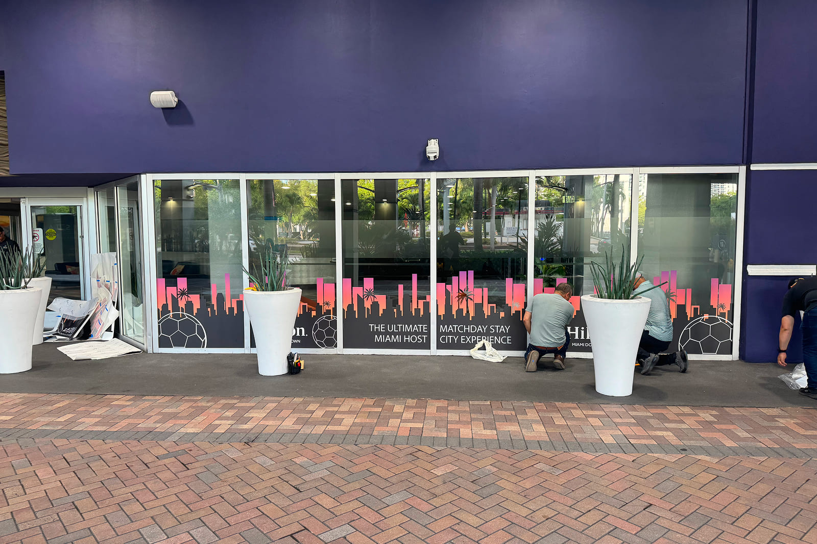 Custom Hilton Miami Downtown window graphics installed as part of the Match Day Stay Host City Experience, transforming the hotel's exterior with tournament-inspired branding.