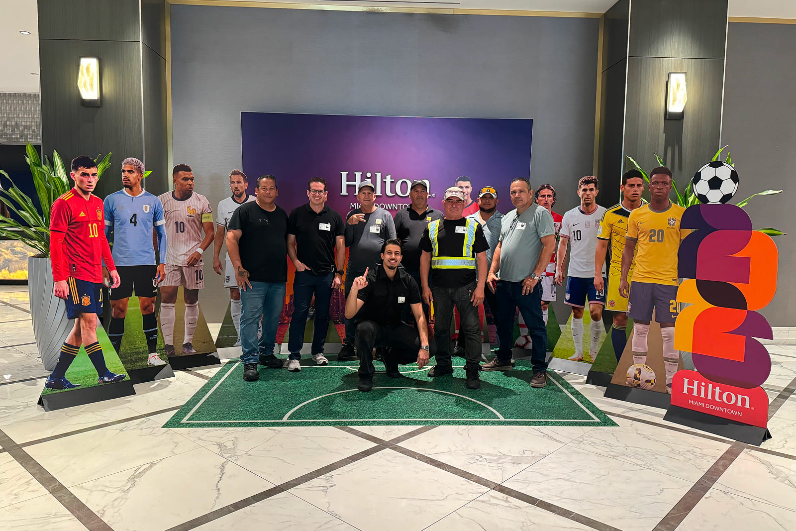 A3 Visual team members celebrating the completion of the Match Day Stay Host City Experience installation at Hilton Miami Downtown.