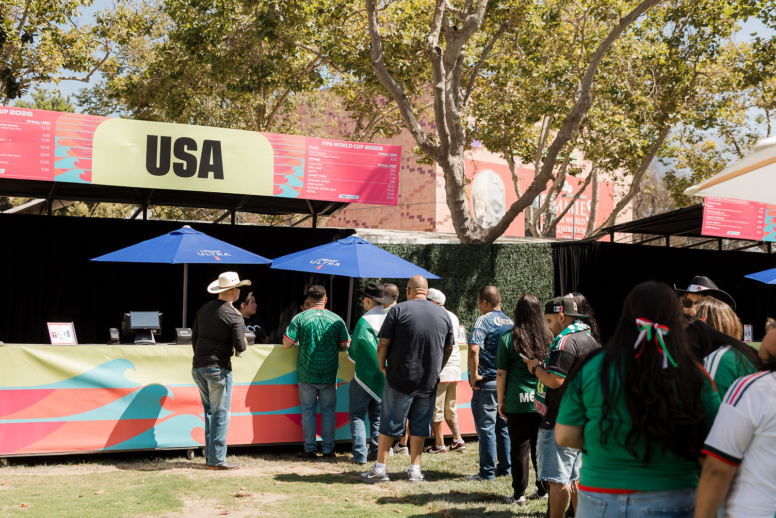 Guests entering FIFA Fan Fest beneath custom entrance graphics and branded environmental displays at the Los Angeles Memorial Coliseum.