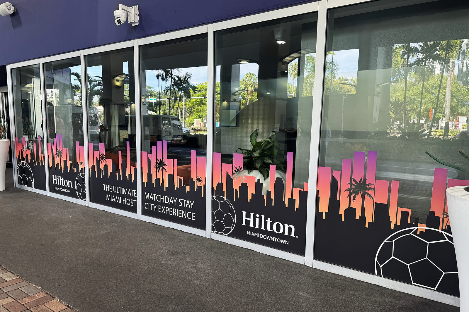 Close-up of tournament-inspired window graphics at Hilton Miami Downtown, enhancing the guest arrival experience.