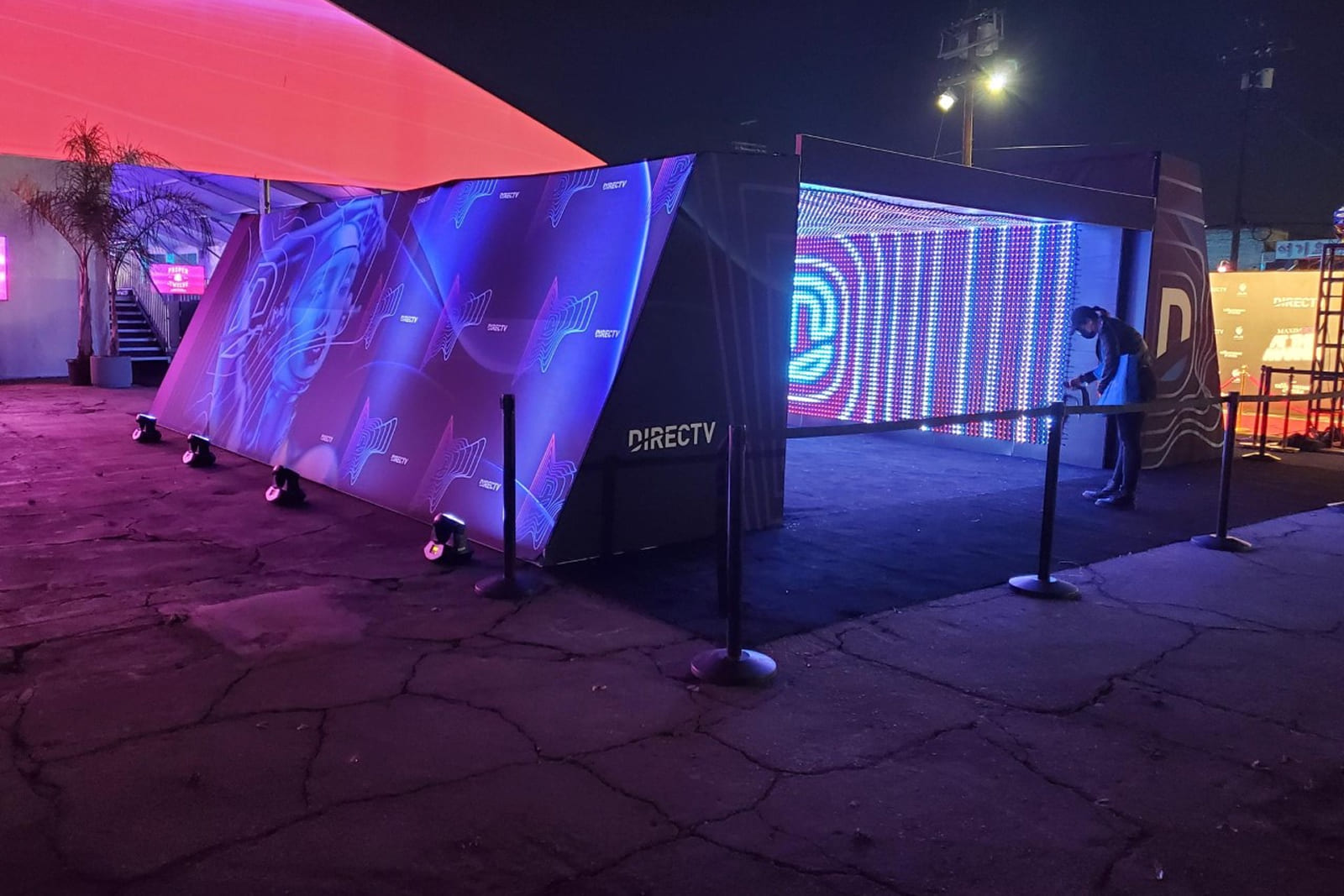 Exterior view of the DIRECTV tunnel activation highlighting custom branded graphics and the illuminated LED entrance.