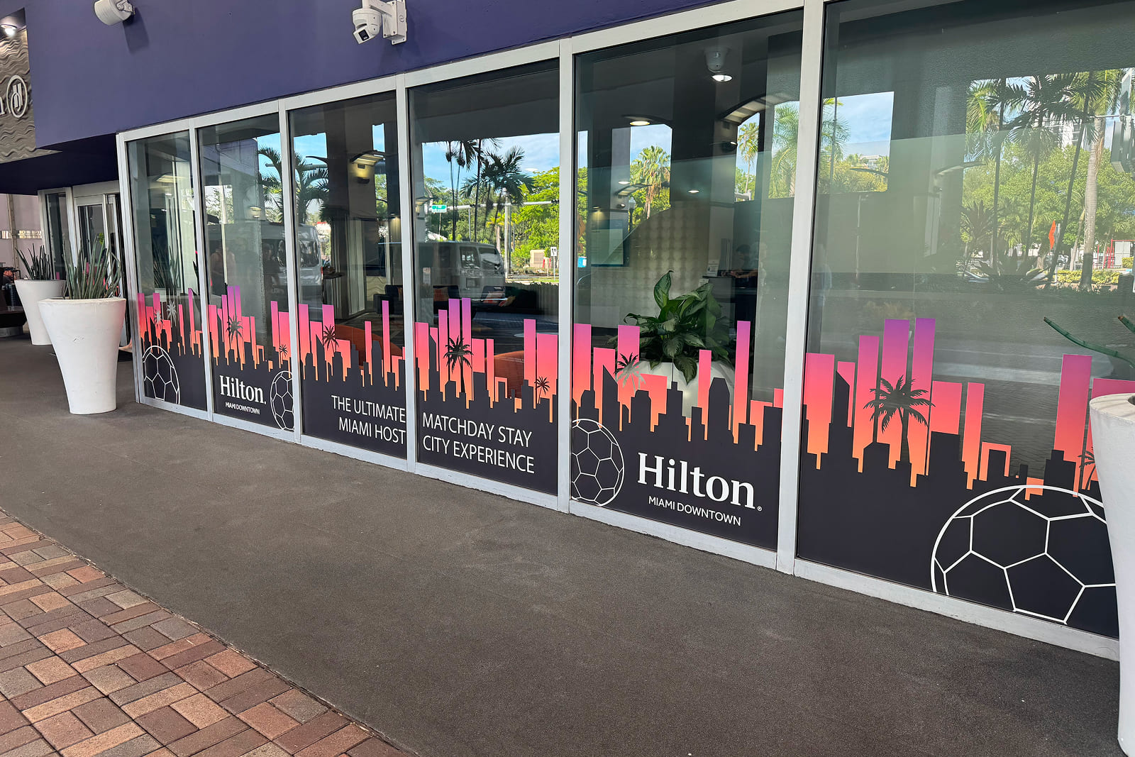 Custom environmental graphics spanning the exterior windows of Hilton Miami Downtown for the Match Day Stay Host City Experience.