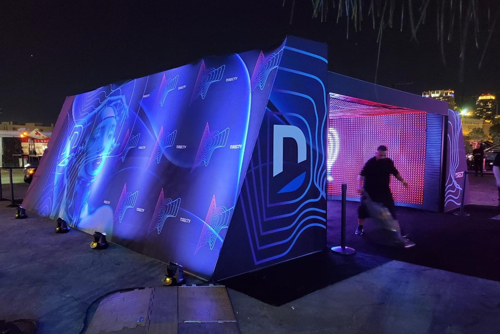 Exterior perspective of the DIRECTV tunnel installation featuring large-format branded graphics and experiential event design.