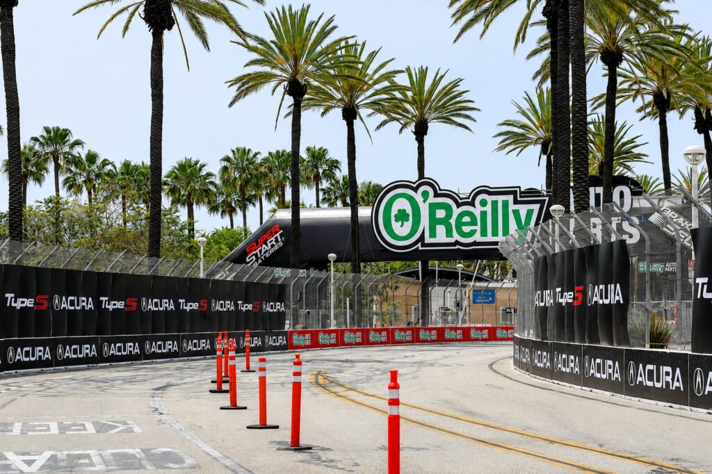 Large-format sponsor and event graphics installed along pedestrian walkways at the Acura Grand Prix of Long Beach.
