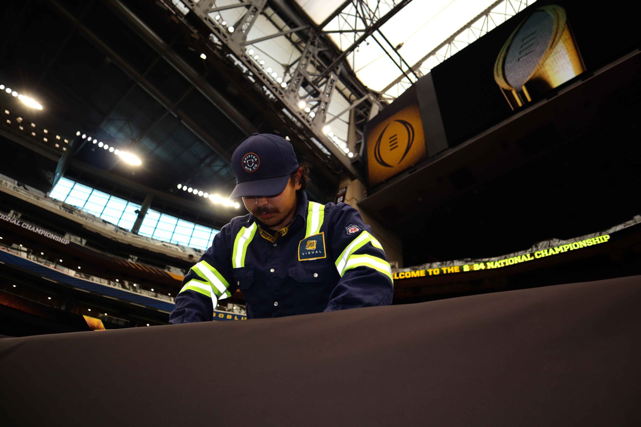 A3 Visual installation team installing fabric field branding at NRG Stadium for the 2024 College Football Playoff National Championship.