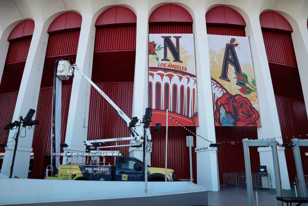 A3 Visual installation team installing large-format fabric graphics on the iconic Kia Forum arches.