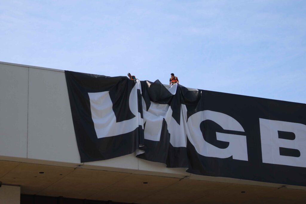 A3 Visual installation team installing large-format fabric graphics at the Long Beach Convention Center for the 2026 Acura Grand Prix of Long Beach.