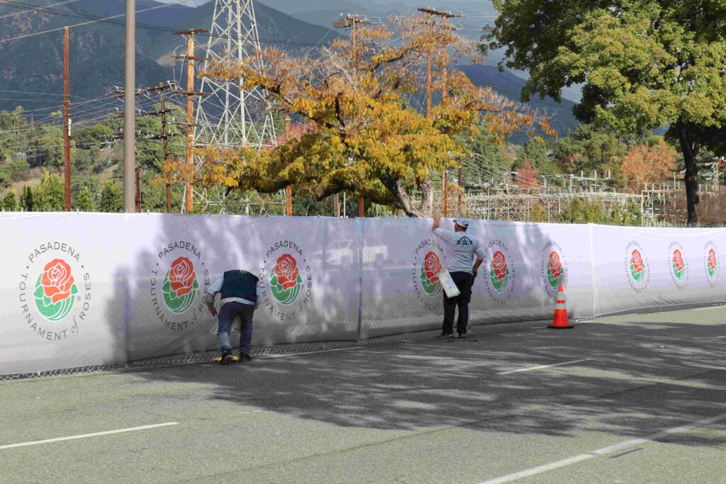 A3 Visual installation team installing large-format fence banners along the Rose Parade route for the Tournament of Roses.