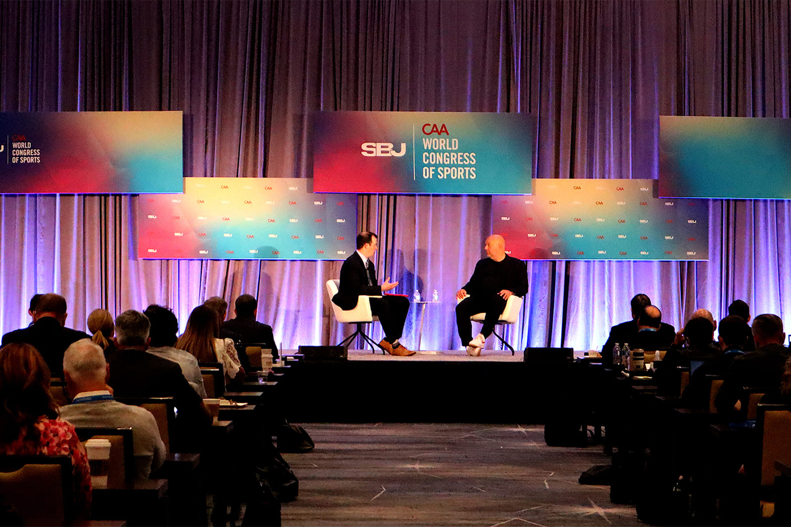 Attendees watch a keynote session at the Sports Business Journal World Congress of Sports with custom stage branding, backdrops, and event graphics by A3 Visual.
