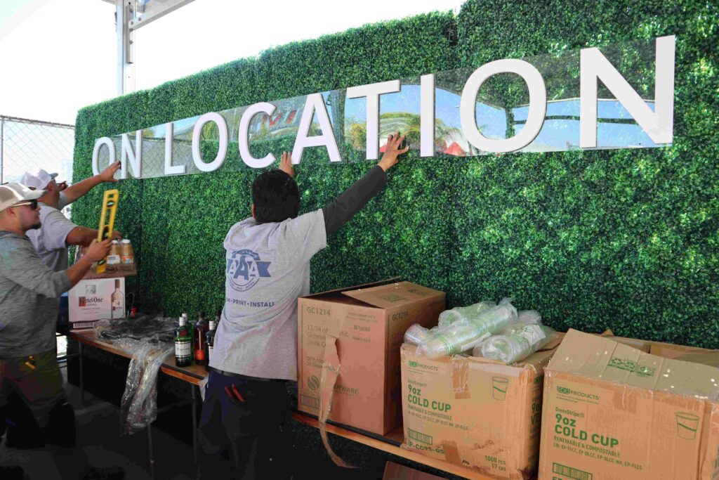 A3 Visual installation team installing On Location branded graphics on a living wall backdrop for Super Bowl LVI.